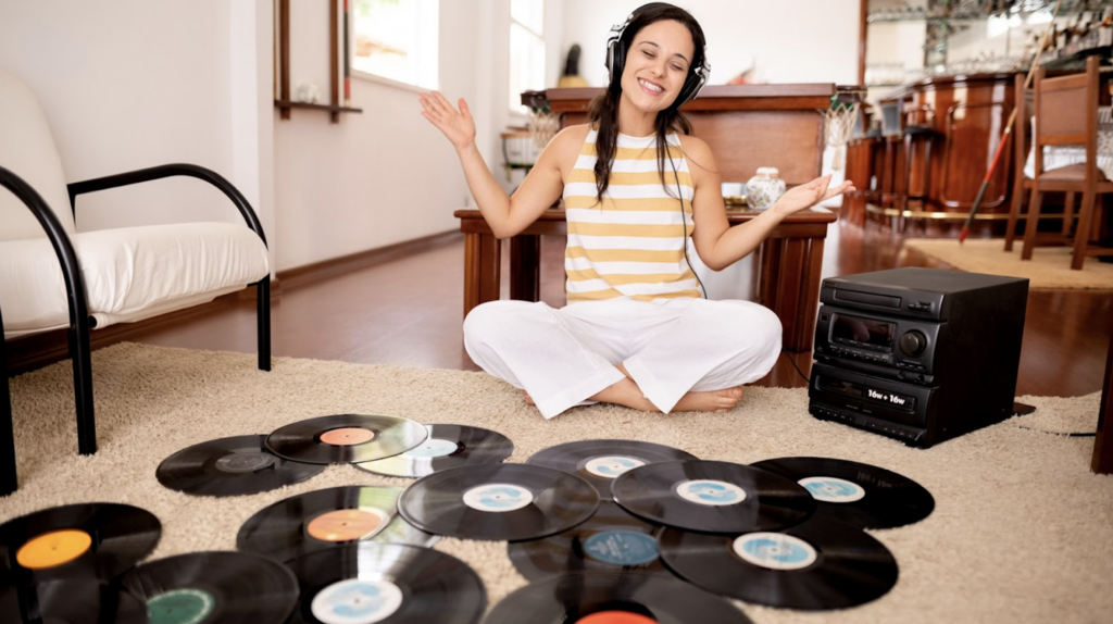 A women sitting on the floor with vinyl records scattered around